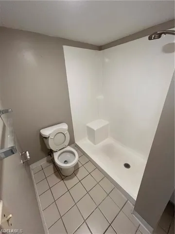 Bathroom with a stall shower, tile patterned floors, and a textured ceiling