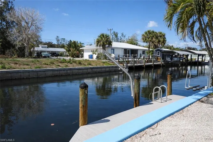 Waterfront property featuring a private boat dock, boat lift, and seawall