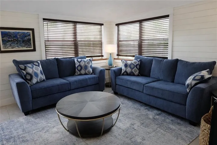 Two large windows featuring dark wood-finish blinds