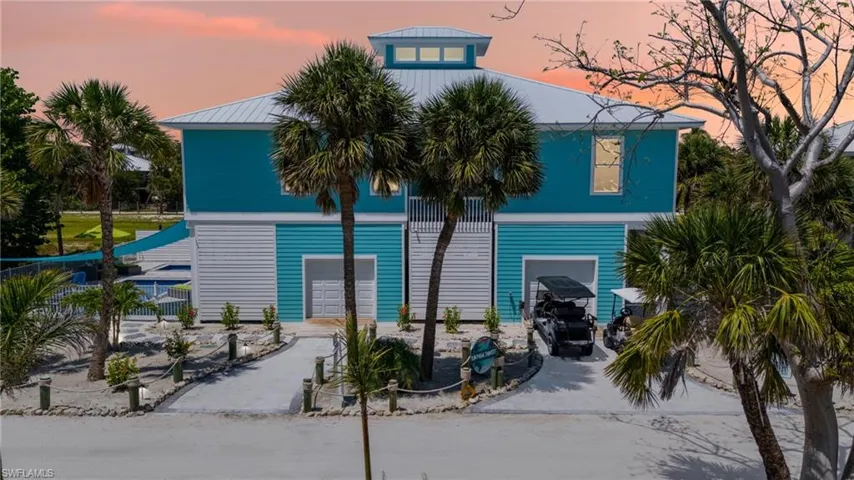 Front of House at dusk featuring driveway and garages