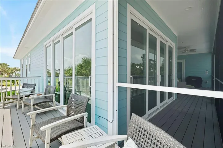 Corner where the open balcony and the screened in one meet, showing sliders from both walls in the dining room.