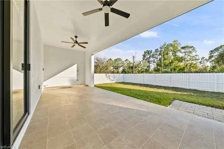 Fenced backyard featuring ceiling fan and a patio