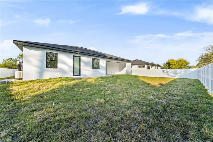 Back of house with a fenced backyard, a patio area, and stucco siding