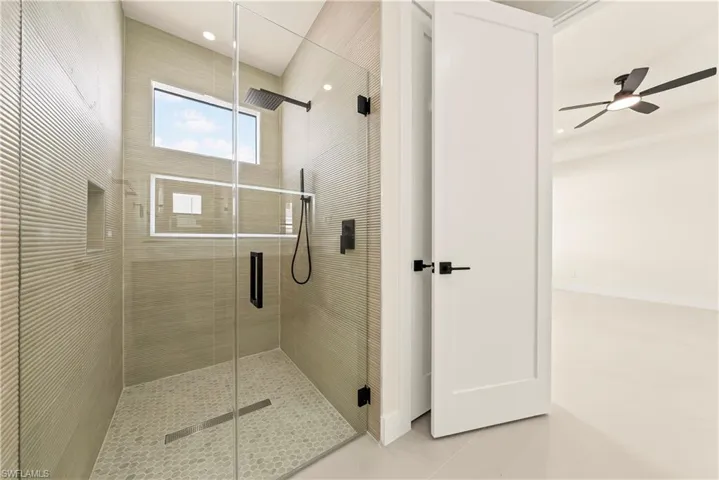 Full bathroom with a stall shower and ceiling fan