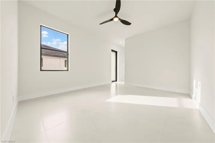 Unfurnished room featuring a ceiling fan and baseboards