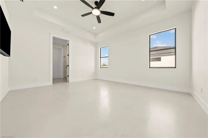 Empty room featuring recessed lighting, a raised ceiling, and a ceiling fan