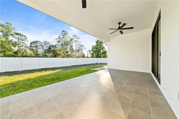 Fenced backyard featuring a patio and ceiling fan