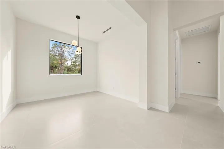 Unfurnished dining area with lofted ceiling and baseboards