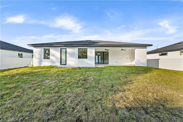 Rear view of property with ceiling fan, a patio area, and stucco siding