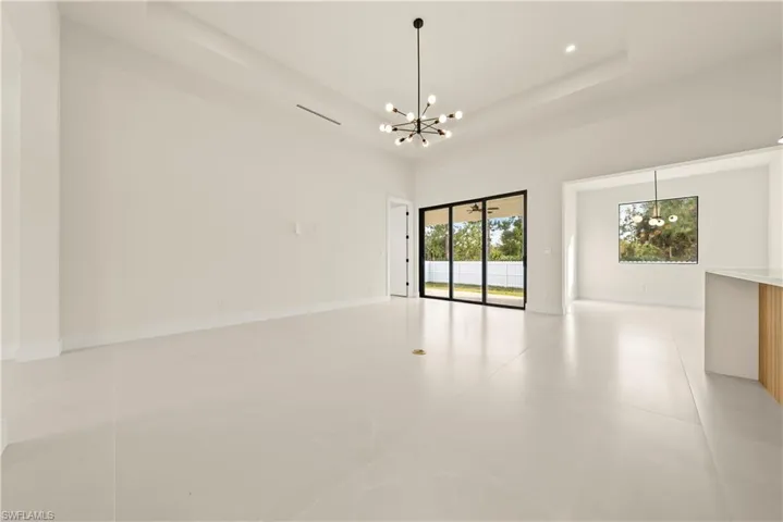 Empty room featuring suspended lighting and a tray ceiling