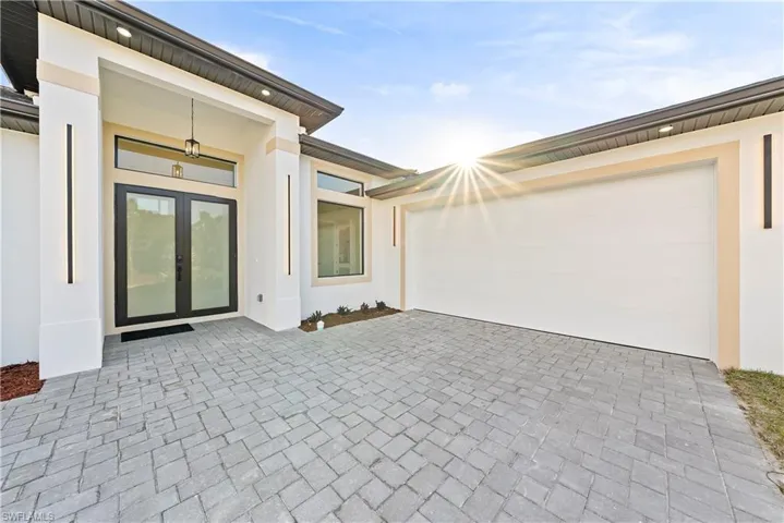 View of patio / terrace with french doors, driveway, and an attached garage