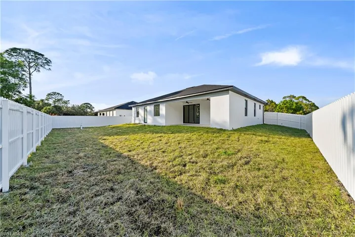 Back of property featuring a fenced backyard, stucco siding, and a patio