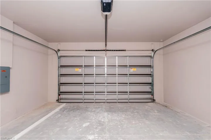 Garage featuring electric panel and a garage door opener