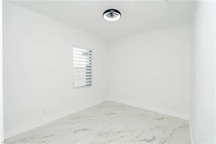 Unfurnished room with baseboards and marble finish floors