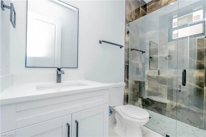 Full bathroom with vanity, a marble finish shower, and marble finish floors