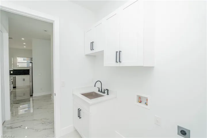 Washroom featuring cabinet space, light marble finish flooring, hookup for a washing machine, hookup for an electric dryer, and recessed lighting