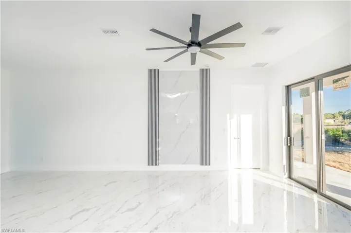 Unfurnished room featuring light marble finish flooring and ceiling fan
