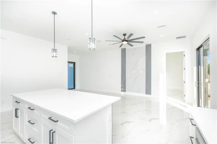 Kitchen featuring decorative light fixtures, light marble finish flooring, white cabinets, a ceiling fan, and recessed lighting