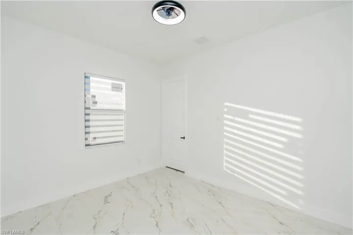 Spare room with baseboards and light marble finish floors