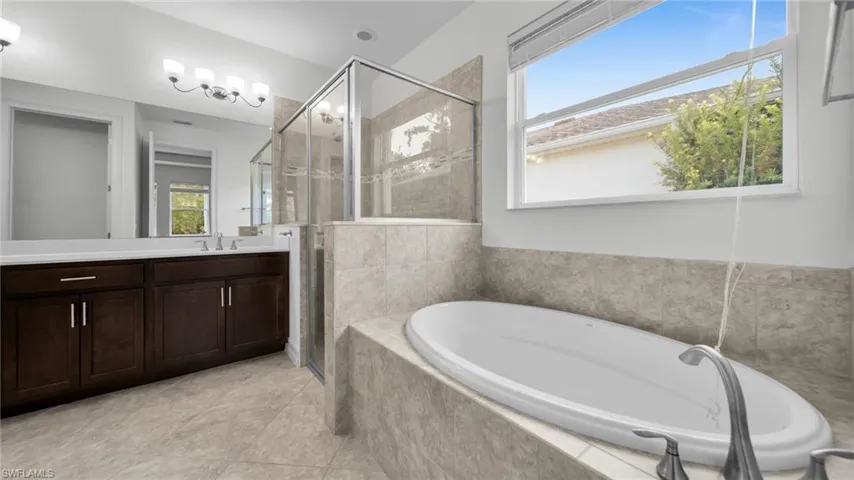 Master Bathroom with Full bath * shower stall * a garden tub, and tile  flooring