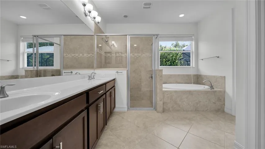 MASTER Bathroom featuring a garden tub, a stall shower, tile  flooring, double vanity