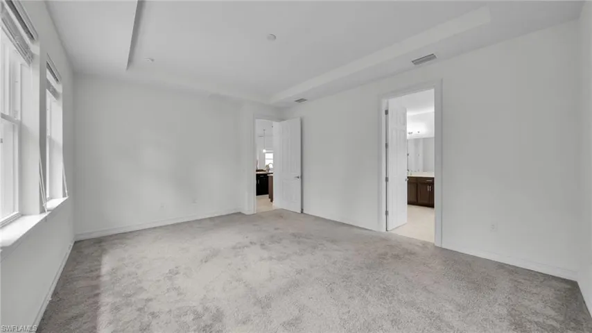 Master Bedroom Carpeted floor with Tall raised ceiling,  connected to Master Bathroom off Kitchen