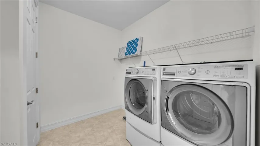 Huge Laundry room featuring washer and dryer and tile floors, plumber for a laundry sink