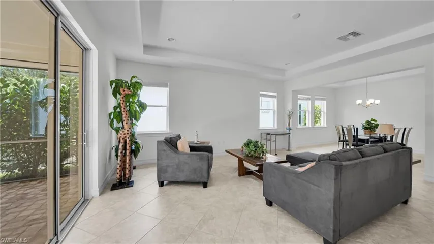 Great Room Living with tall tray ceiling and tile flooring