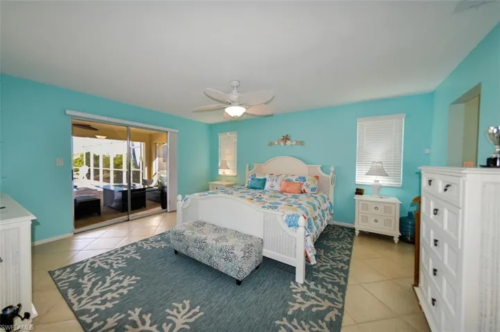 Primary Bedroom featuring ceiling fan, sliders to the lanai