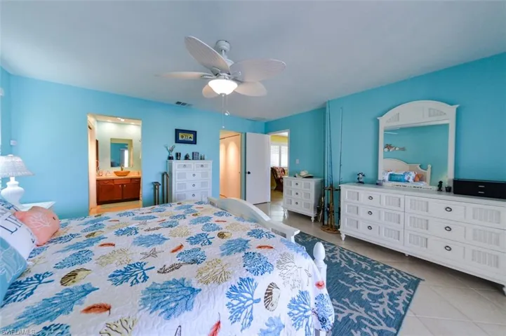 Primary bedroom with ceiling fan and en suite bathroom