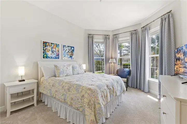 Guest Bedroom with light colored carpet and multiple windows
