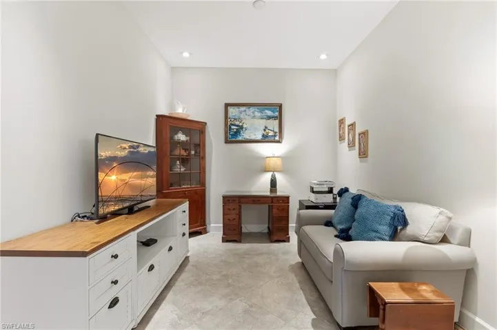Den Living area with baseboards and a desk