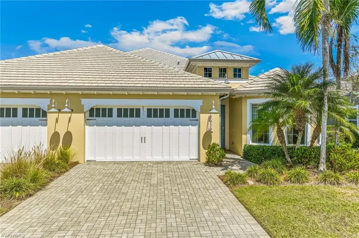 View of front of home with decorative driveway, an attached garage, stucco siding, and a tiled roof