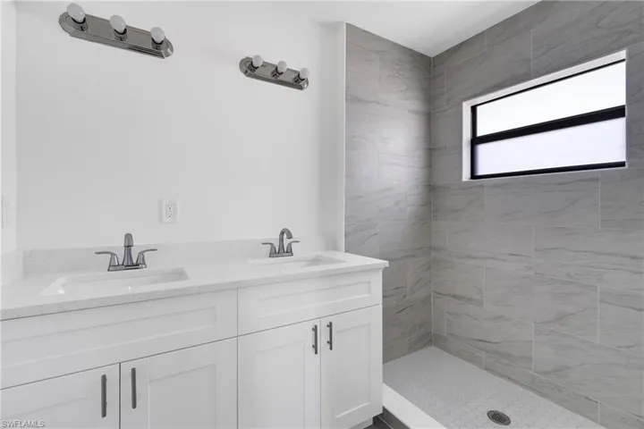 Bathroom with double vanity and a shower stall