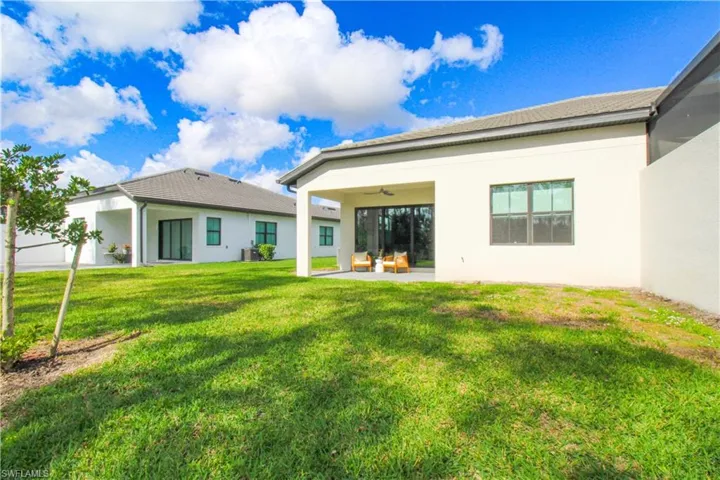 Back of property featuring a patio and a lawn