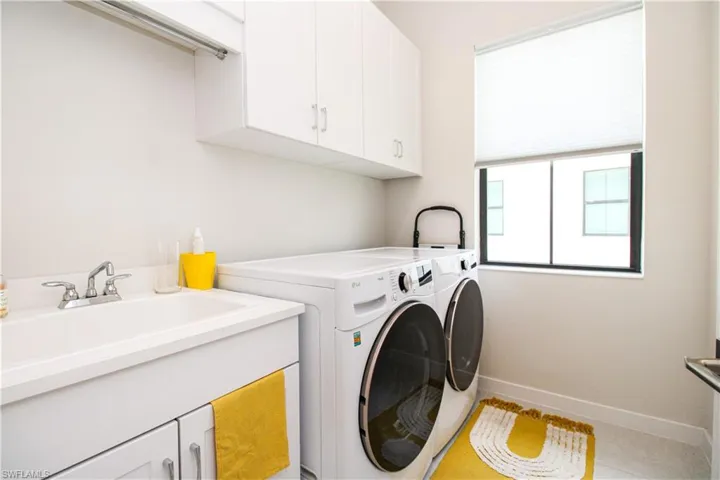 Washroom featuring sink, separate washer and dryer, cabinets, and tile patterned floors
