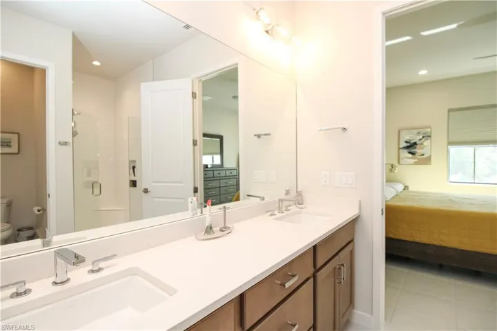 Bathroom featuring vanity, tile patterned flooring, toilet, and walk in shower