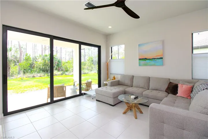 Living room with light tile patterned flooring and ceiling fan