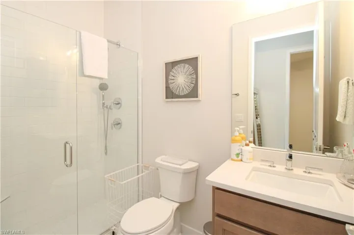 Bathroom with vanity, a shower with door, and toilet
