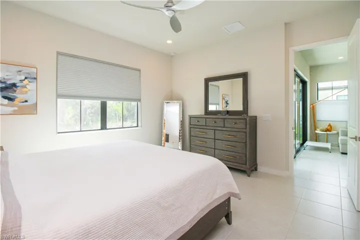 Tiled bedroom featuring ceiling fan