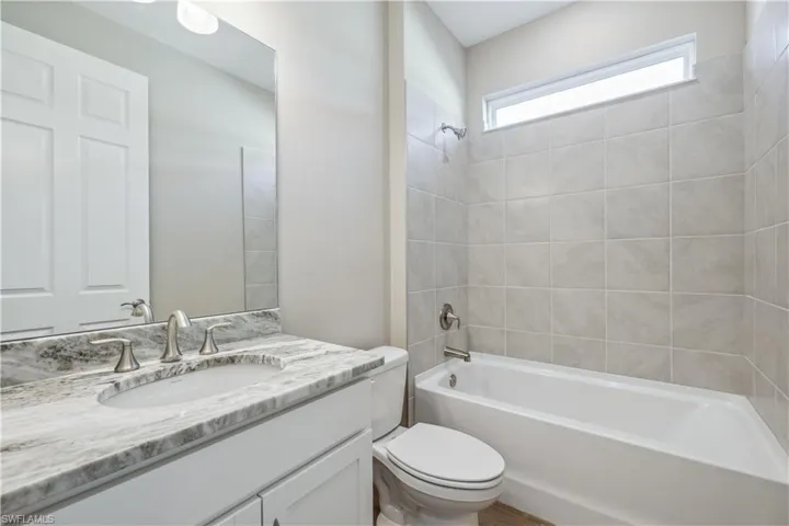 Full bathroom featuring toilet, vanity, and tiled shower / bath