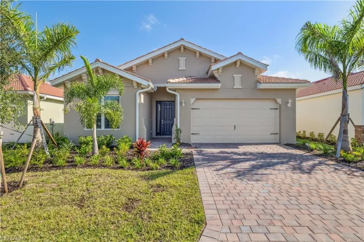 Mediterranean / spanish-style home with a front yard and a garage