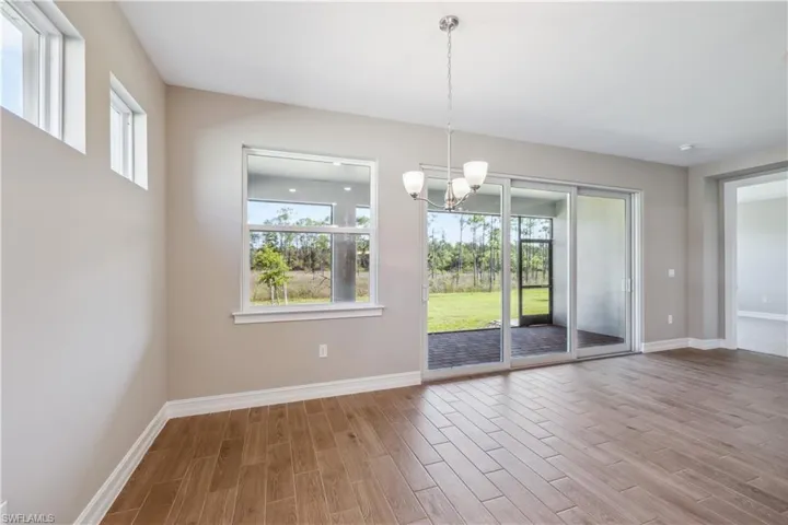 Unfurnished dining area with light wood-type flooring and an inviting chandelier