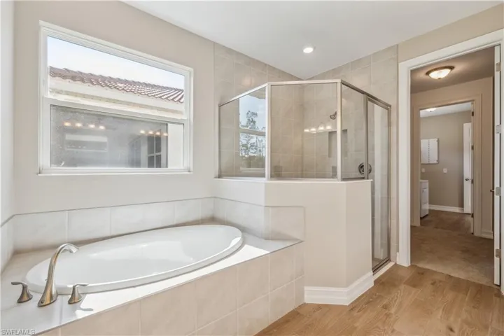 Bathroom with hardwood / wood-style floors and separate shower and tub
