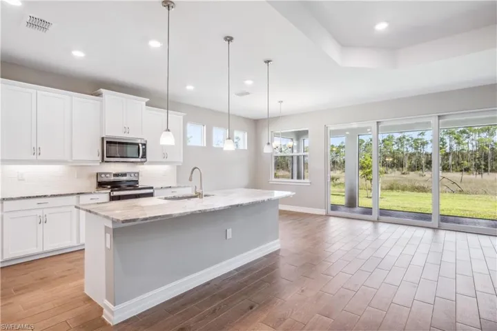 Kitchen with white cabinets, appliances with stainless steel finishes, plenty of natural light, and sink