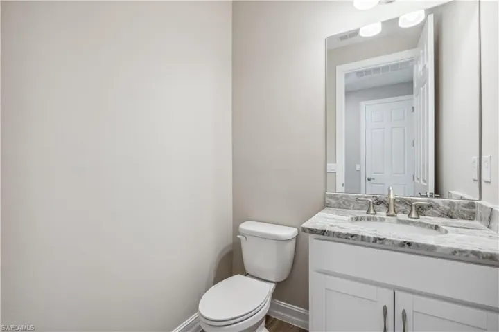 Bathroom with wood-type flooring, vanity, and toilet