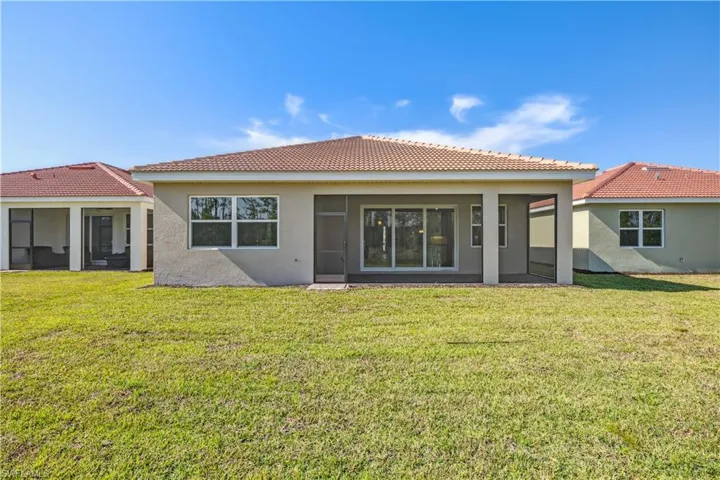 Back of house featuring a yard and a sunroom