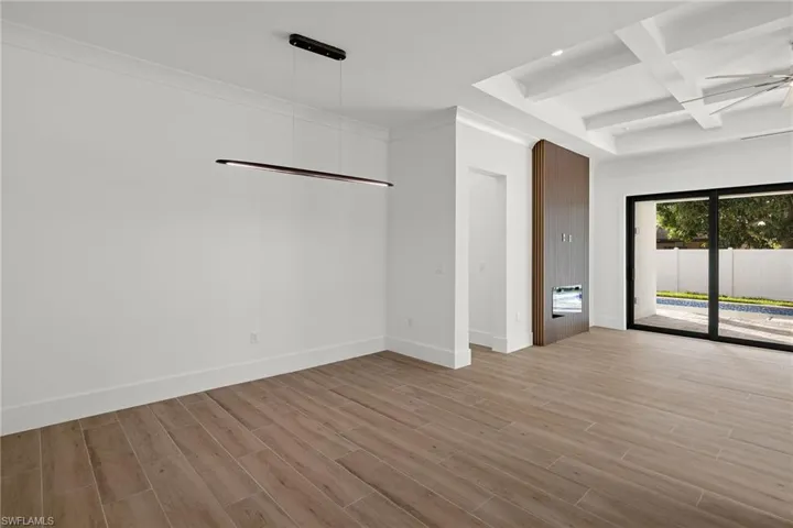 Unfurnished room with ceiling fan, light hardwood / wood-style floors, beam ceiling, and coffered ceiling