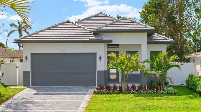 View of front facade featuring a front yard and a garage
