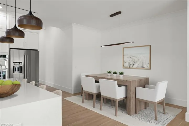 Dining space with ornamental molding and light hardwood / wood-style floors